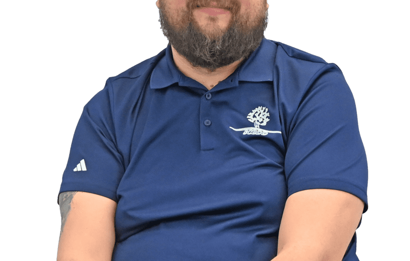 Andrew Martinez, Service and Support Administrator, wearing navy blue Adidas polo shirt with organizational logo