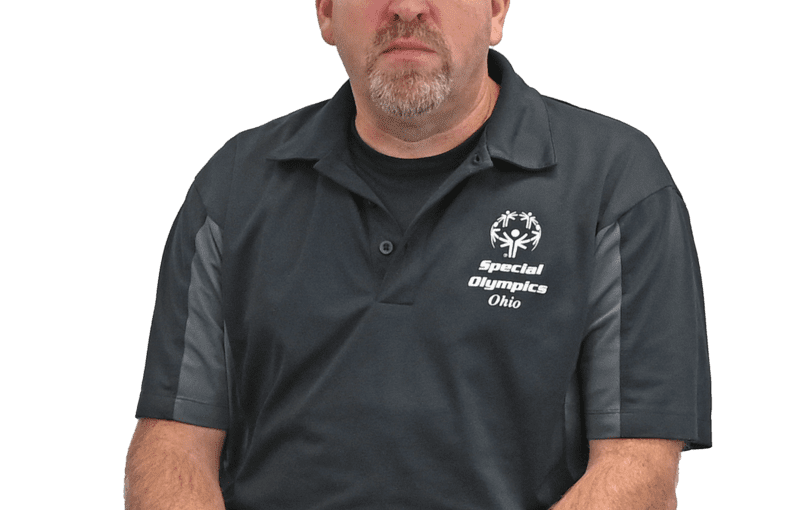 Ed McClain, Special Olympics and Self-Advocacy Coordinator for Special Olympics Ohio, sitting and holding a bocce ball