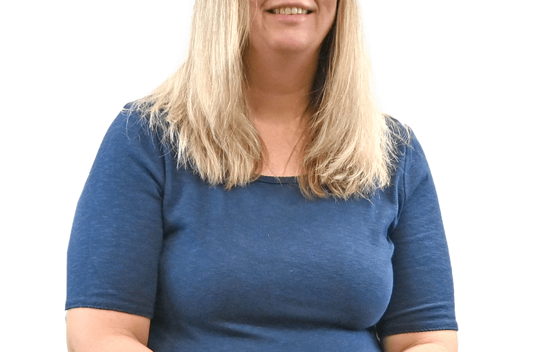 Michelle Hoepf, SSA Comptroller, smiling woman with long blonde hair and glasses wearing a blue shirt against a white background