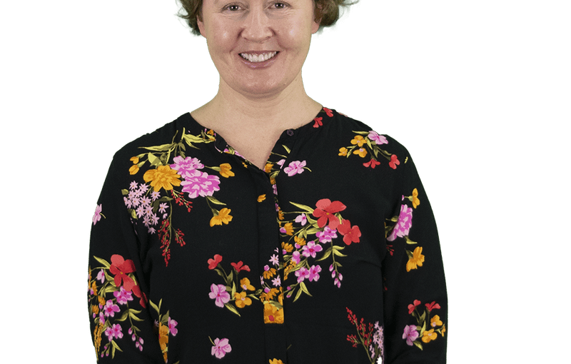 Rebecca Dalton, Service and Support Administrator, smiling at camera wearing black floral blouse against white background