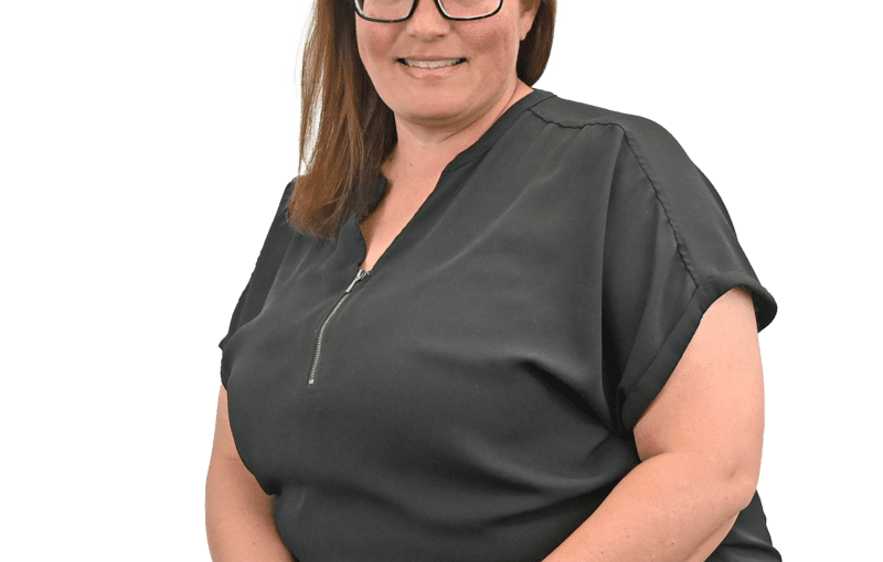 Shelli Blosser, disability services specialist in Sandusky County Ohio, wearing glasses and dark scrubs, smiling at camera in professional portrait