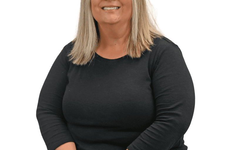 Tami Hrebic, SSA Intake and Eligibility specialist, smiling at camera wearing black long-sleeve shirt and jeans