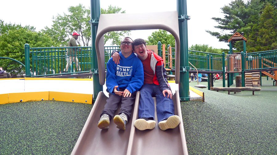 Two adults enjoying a playground slide together at a recreational facility in Sandusky County, Ohio